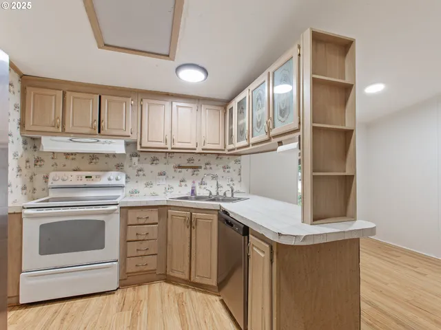 a kitchen with stainless steel appliances granite countertop a sink stove and cabinets