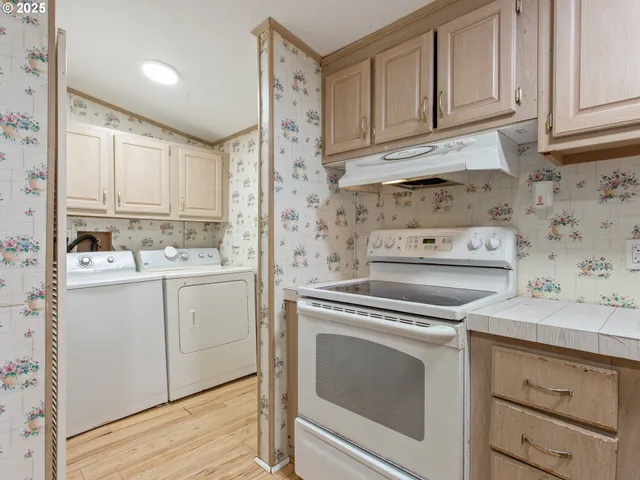 a kitchen with granite countertop white cabinets and white appliances