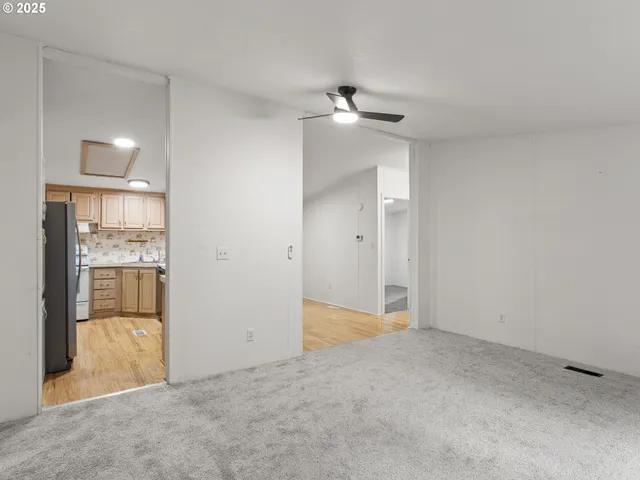 an empty room with closet and a chandelier fan