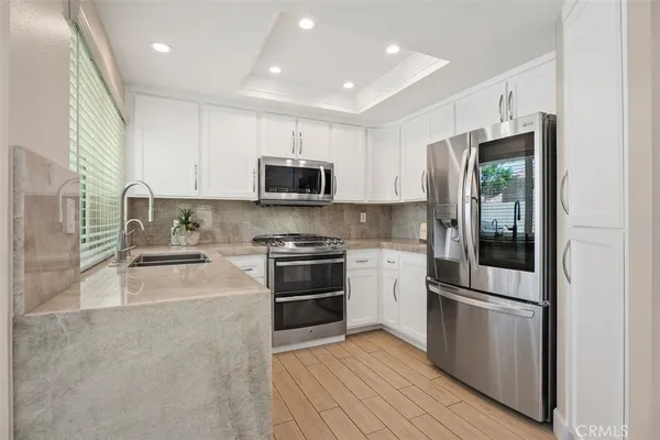 a kitchen with stainless steel appliances granite countertop a stove a sink and a refrigerator