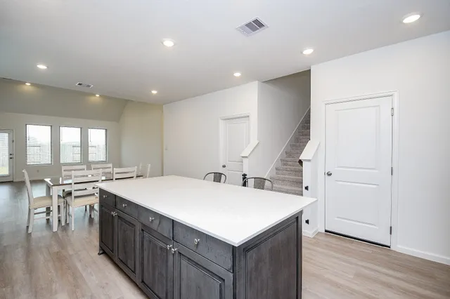 a kitchen with a stove a refrigerator and wooden floor