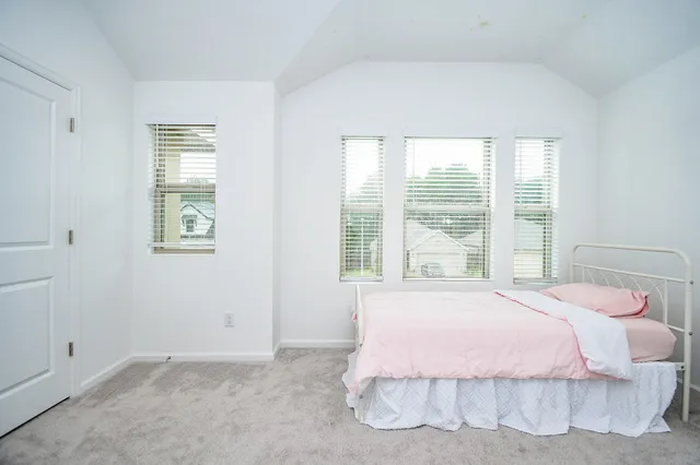 a bedroom with a bed and a large window