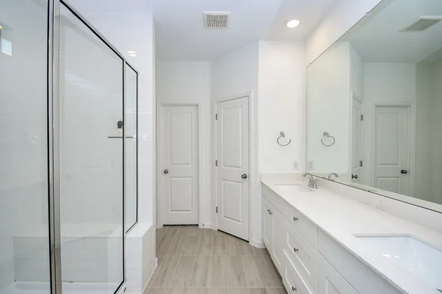 a spacious bathroom with a double vanity sink and a mirror