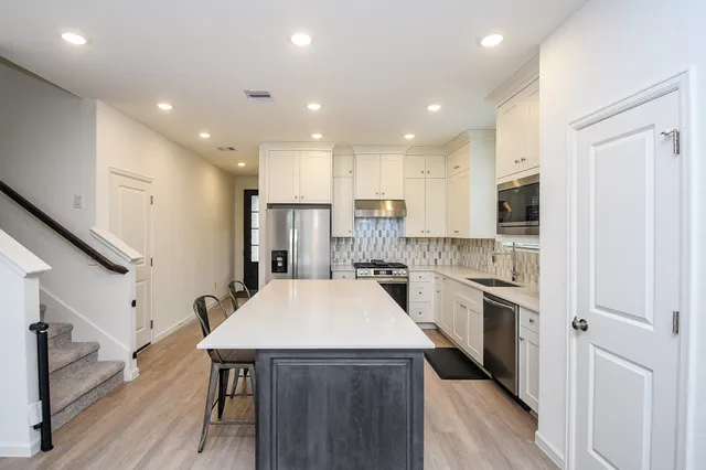a kitchen with stainless steel appliances a refrigerator and a stove top oven