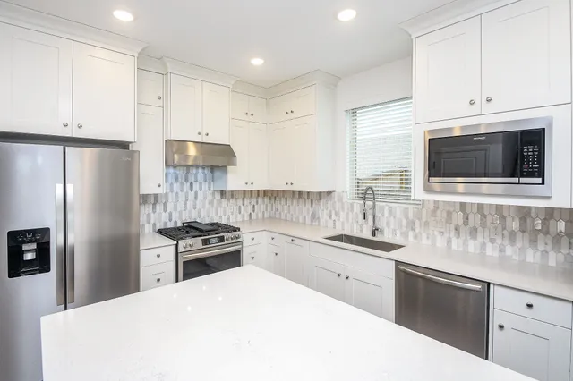 a kitchen with kitchen island a sink stainless steel appliances and cabinets