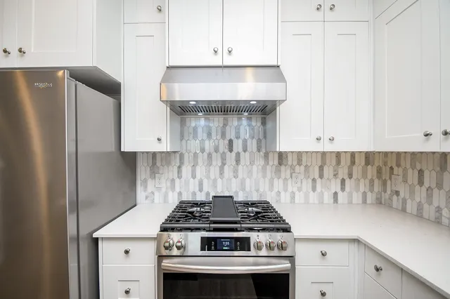 a stove top oven sitting inside of a kitchen