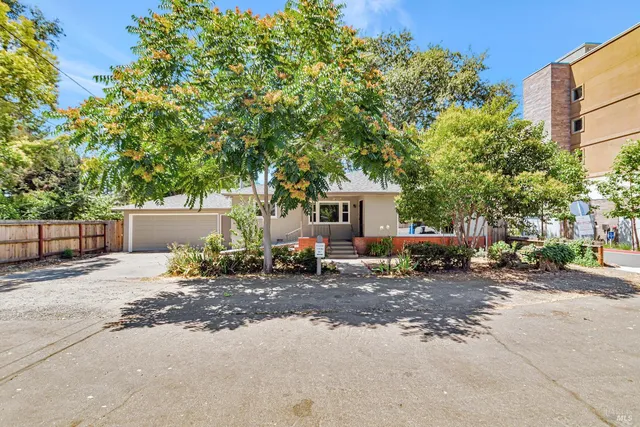 a view of a house with backyard and a car parked in it