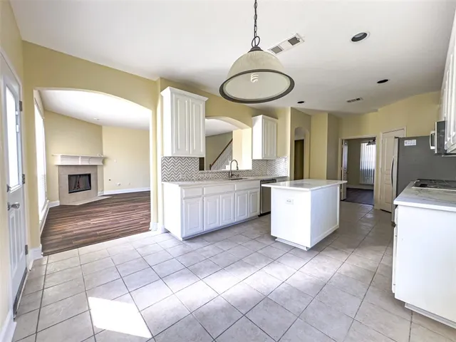 a view of empty room with wooden floor and fireplace