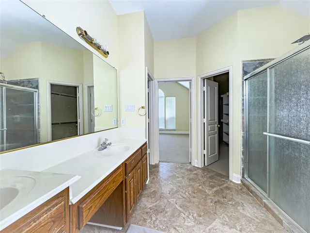 a bathroom with a glass shower door and a mirror
