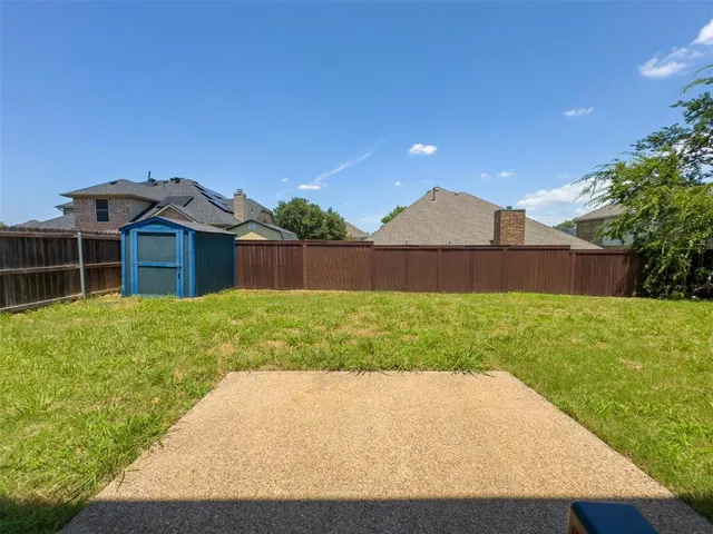 a view of a backyard with table and chairs and wooden fence