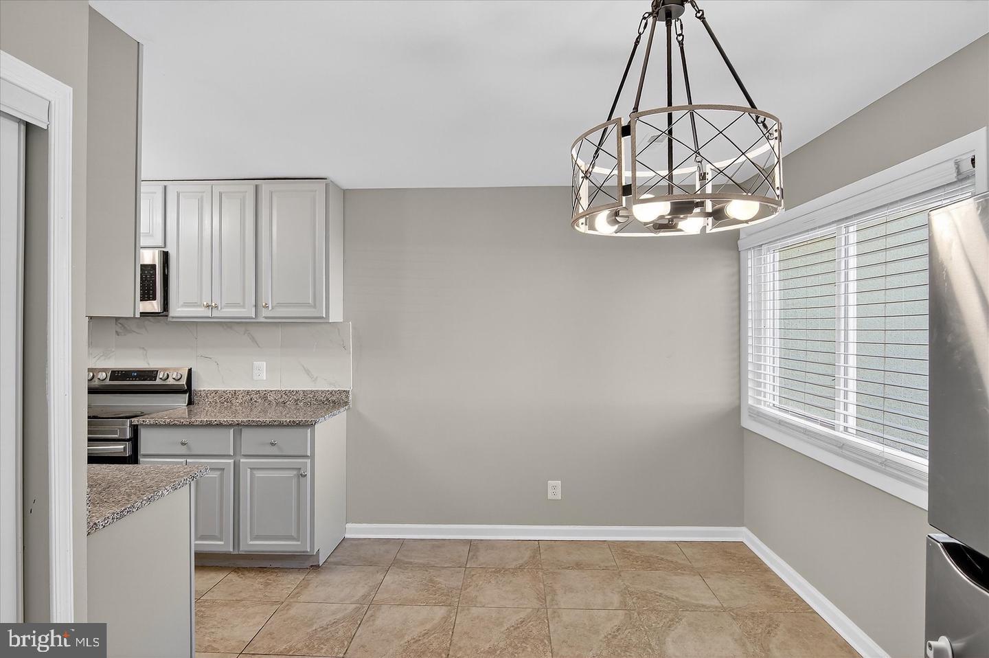 402 Reneau Way Herndon, VA 20170 - Photo 22 of 23 a kitchen with a chandelier and cabinets