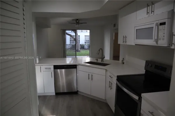 a kitchen with stainless steel appliances a sink stove and cabinets