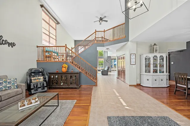 a living room with furniture a flat screen tv and a floor to ceiling window
