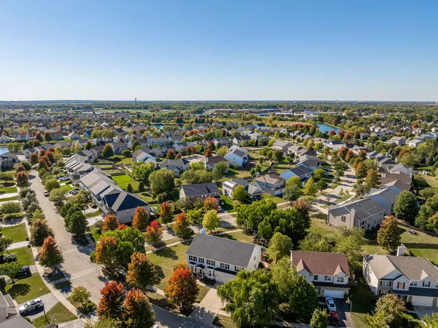 a view of a patio with table and chairs potted plants and a large tree