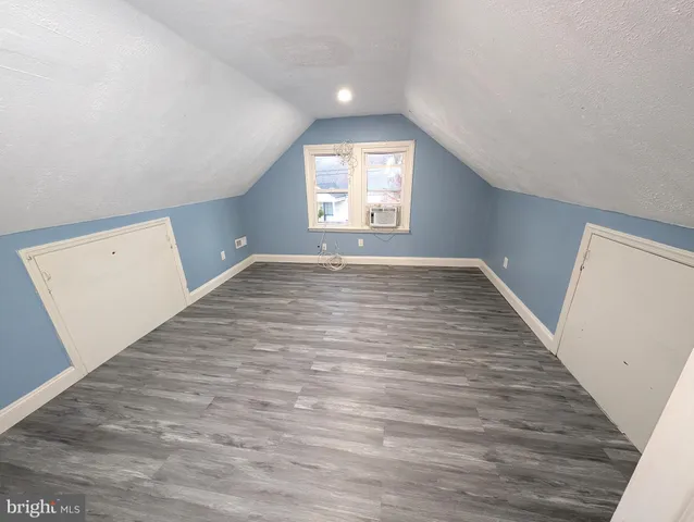 a view of empty room with wooden floor and window