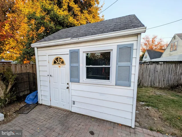 a view of backyard with small garden and wooden fence
