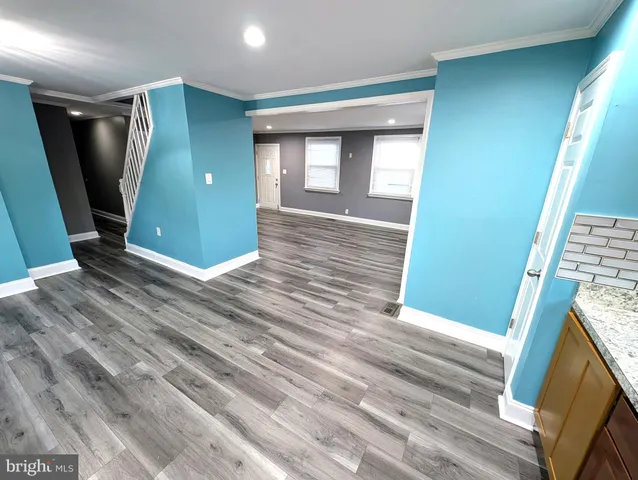 a view of a livingroom with wooden floor and staircase
