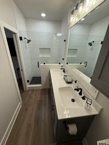 a bathroom with a sink a mirror and shower