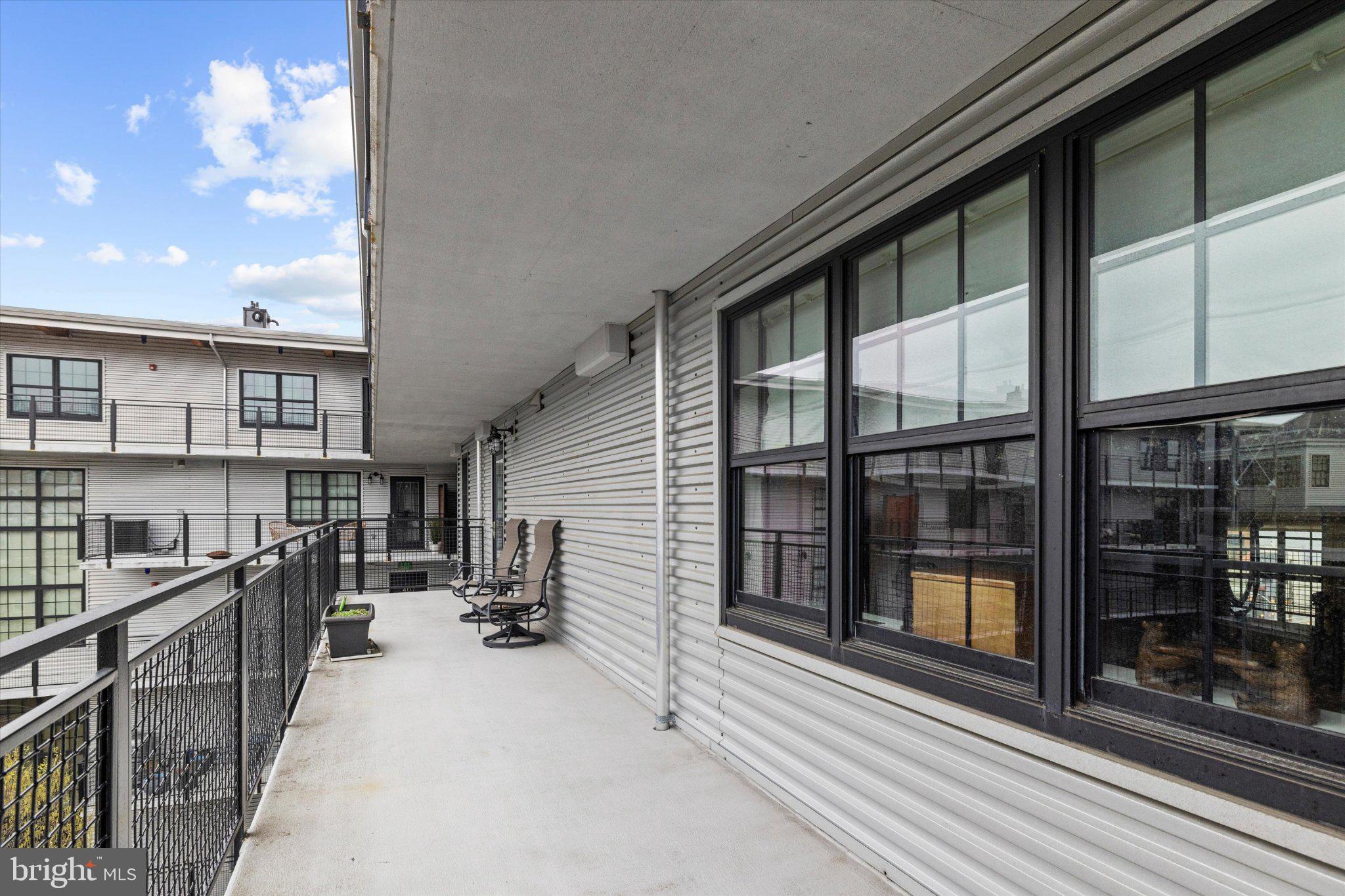 1220 Bank Street, Unit 409 Baltimore, MD 21202 - Photo 45 of 53 a view of a balcony with furniture and floor to ceiling window
