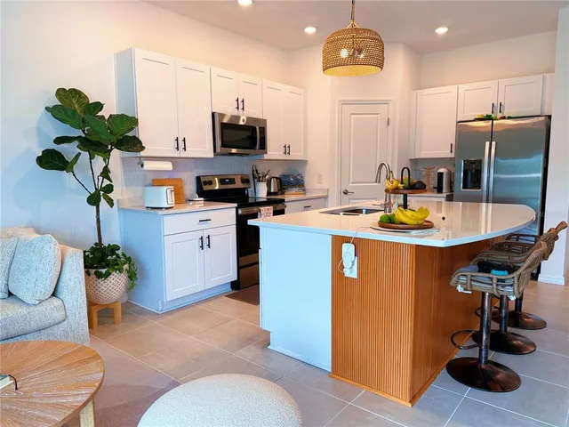 a dining room filled chandelier and kitchen view