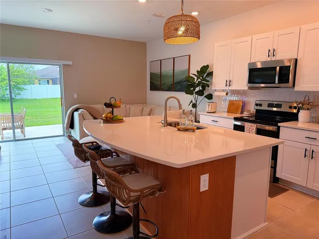 a kitchen with a sink a microwave and cabinets