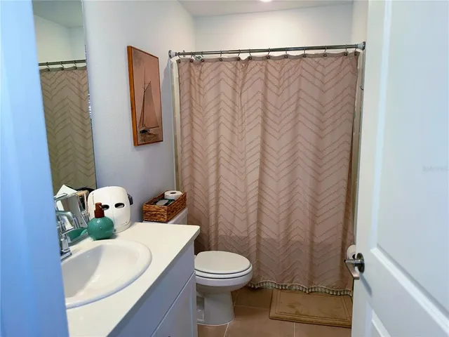 a white toilet sitting next to a shower curtain