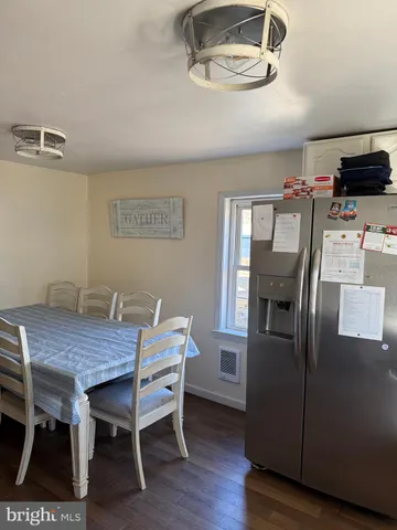 a view of a dining room with furniture wooden floor and a kitchen