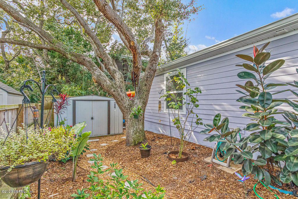 405 2nd Street St. Augustine, FL 32084 - Photo 39 of 49 a backyard of a house with table and chairs and wooden fence