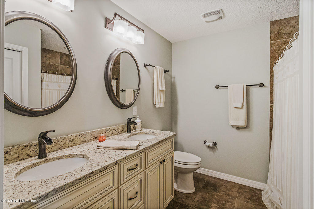 405 2nd Street St. Augustine, FL 32084 - Photo 4 of 49 a bathroom with a granite countertop toilet a sink and a mirror