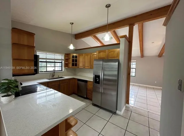 a kitchen with stainless steel appliances granite countertop a refrigerator a sink and a stove
