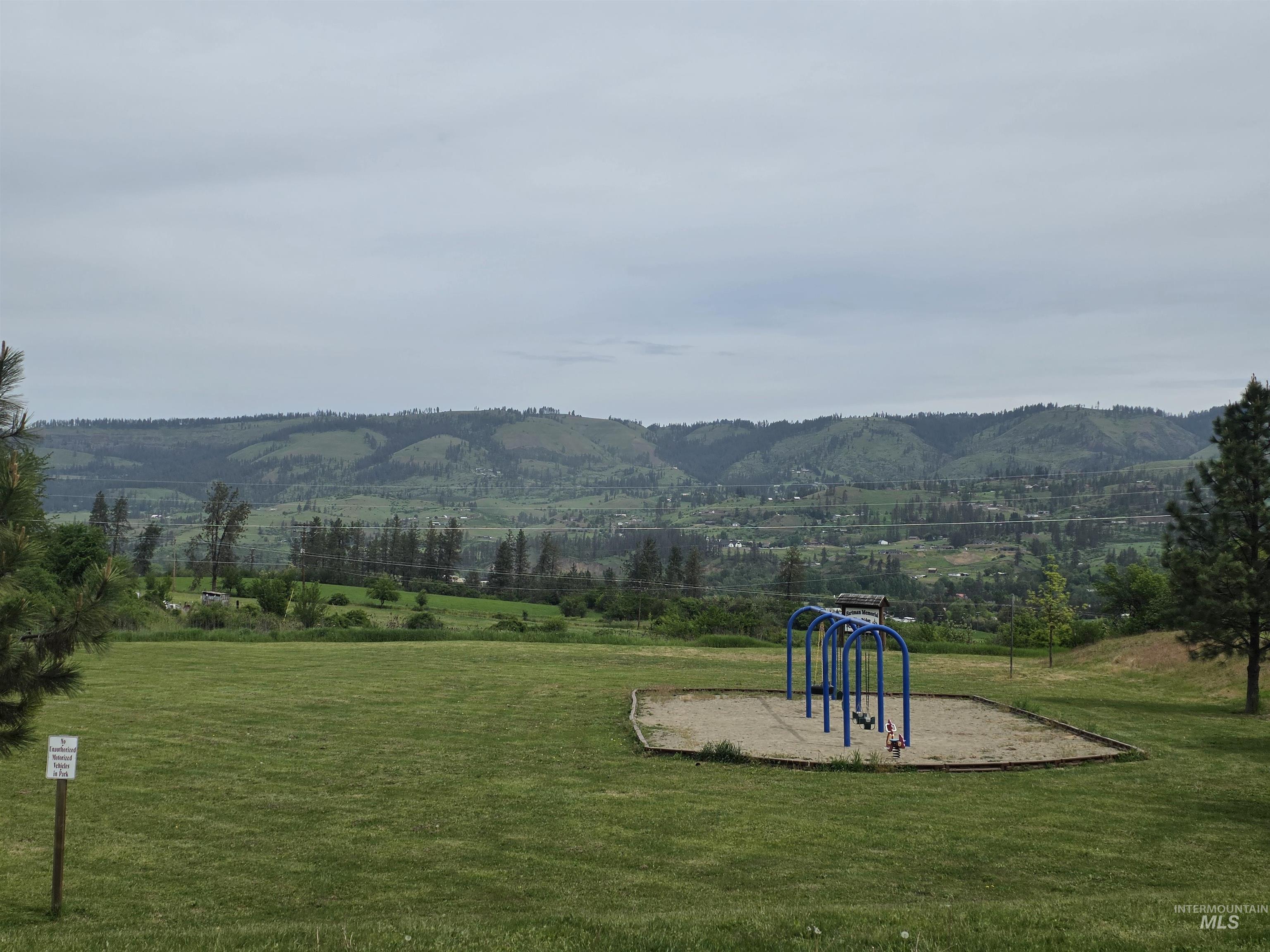 310 Fir Road Kamiah, ID 83536 - Photo 32 of 32 Expansive green space featuring a playground with a blue metal swing set and a sand base