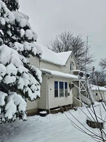 a front view of a house with a tree