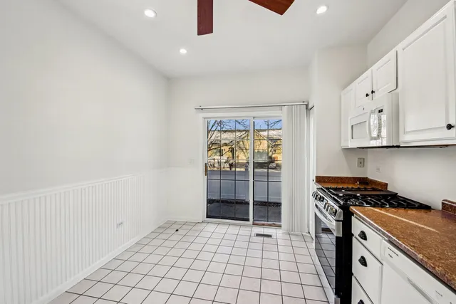 a kitchen with granite countertop a stove a sink and cabinets