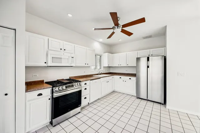a kitchen with cabinets stainless steel appliances and a window