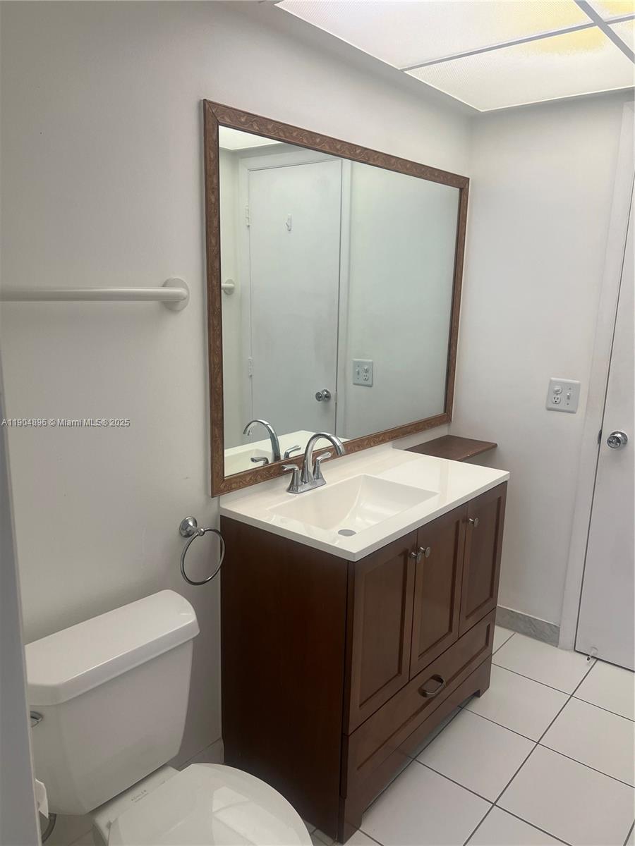 2501 West Golf Boulevard, Unit 128 Pompano Beach, FL 33064 - Photo 15 of 51 a bathroom with a granite countertop sink toilet and mirror