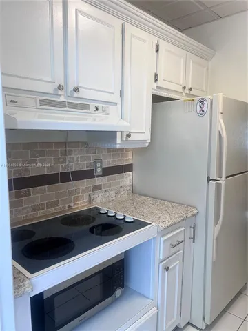 a kitchen with granite countertop a sink and a refrigerator