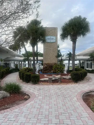 a view of a yard with plants and a barbeque