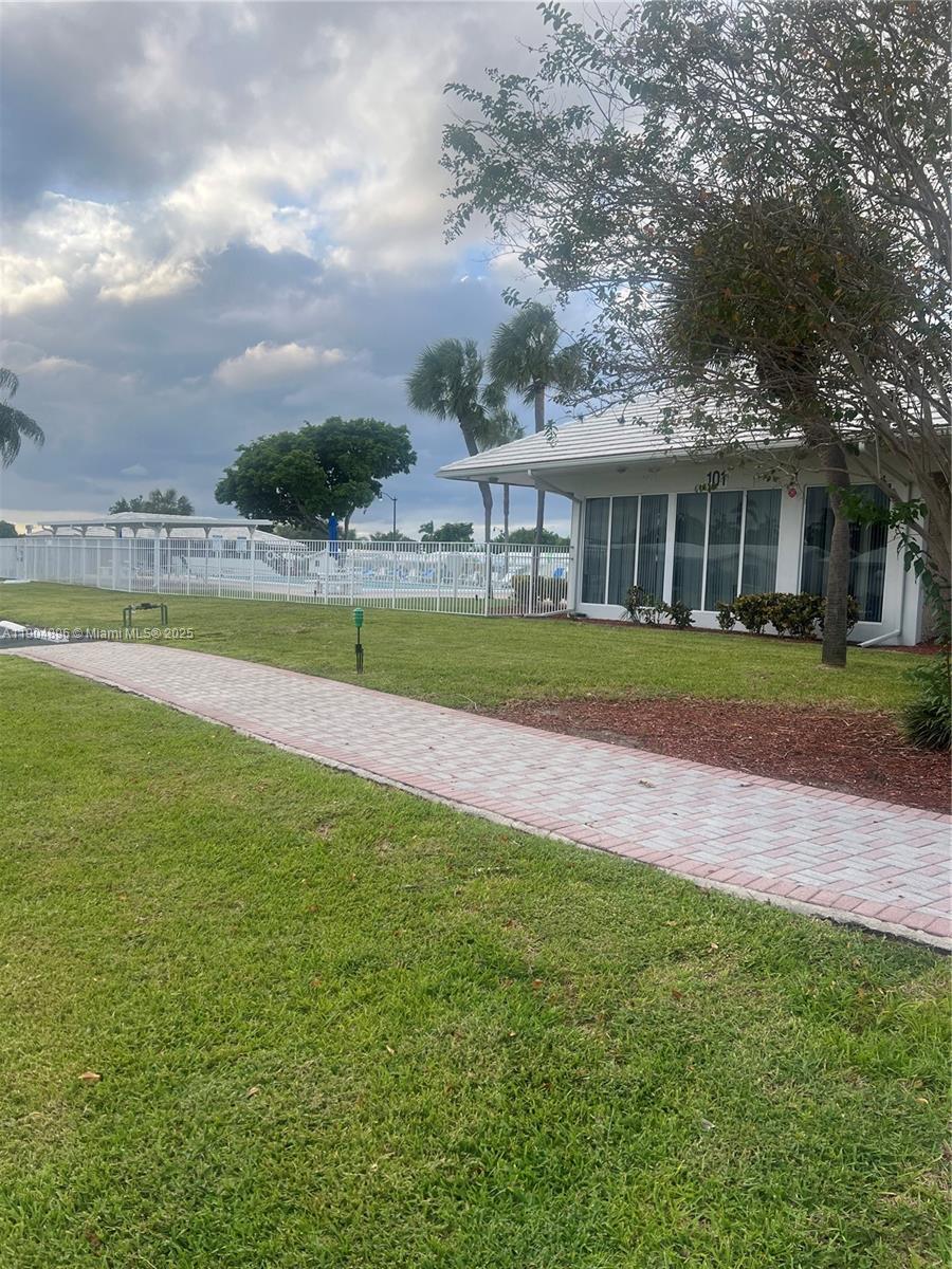 2501 West Golf Boulevard, Unit 128 Pompano Beach, FL 33064 - Photo 38 of 51 a front view of a house with a yard and trees