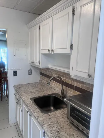 a kitchen with granite countertop a sink and a stove
