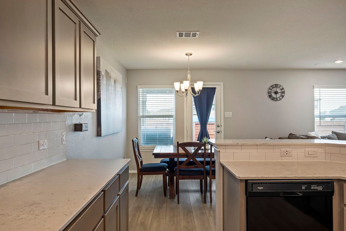 19417 James Carter Jr Street Manor, TX 78653 - Photo 14 of 37 a kitchen with granite countertop a sink appliances and cabinets