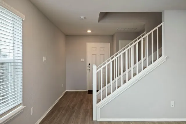 a view of staircase with railing and a window