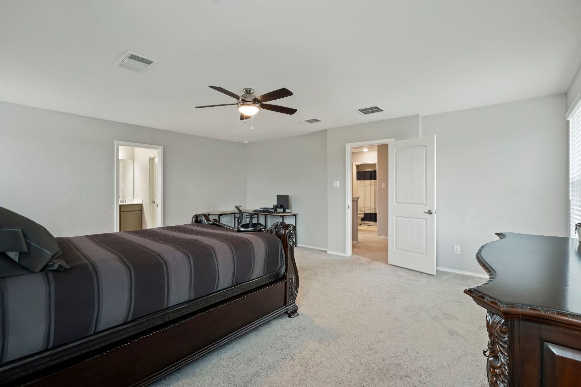 19417 James Carter Jr Street Manor, TX 78653 - Photo 20 of 37 a bed room with a bed and a chair