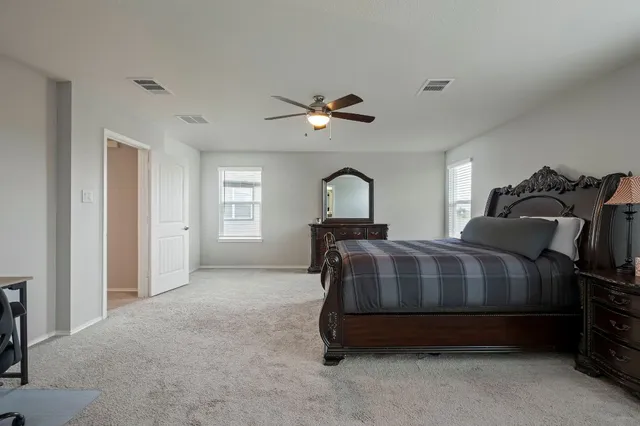 a bedroom with a bed next to a window and a chandelier