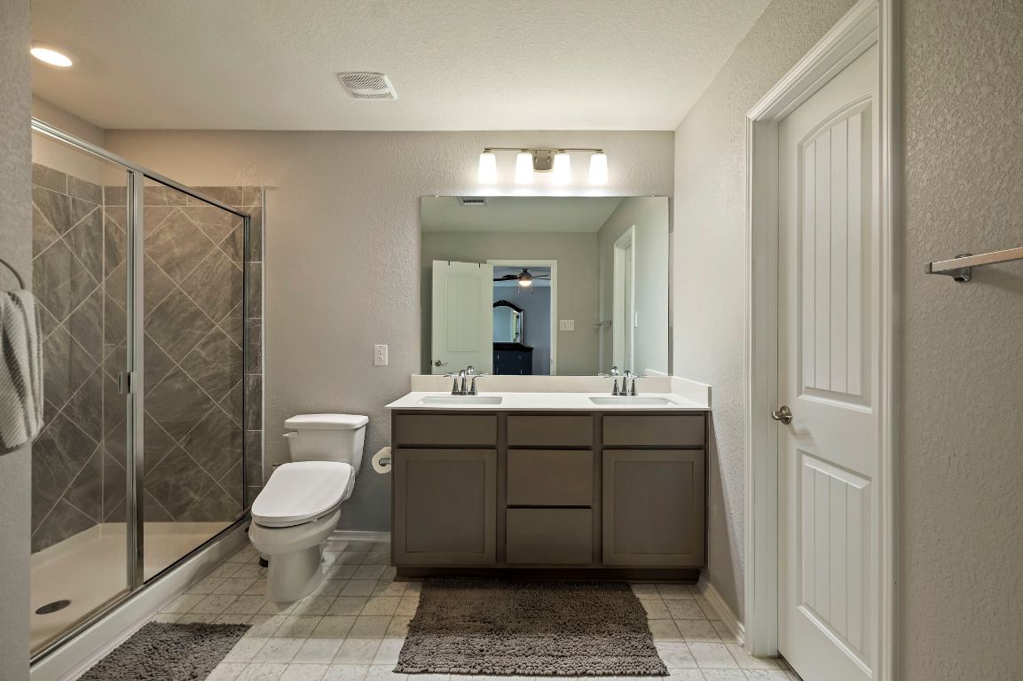 19417 James Carter Jr Street Manor, TX 78653 - Photo 22 of 37 a bathroom with a double vanity sink mirror and toilet