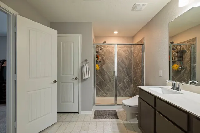a bathroom with a double vanity sink toilet and shower