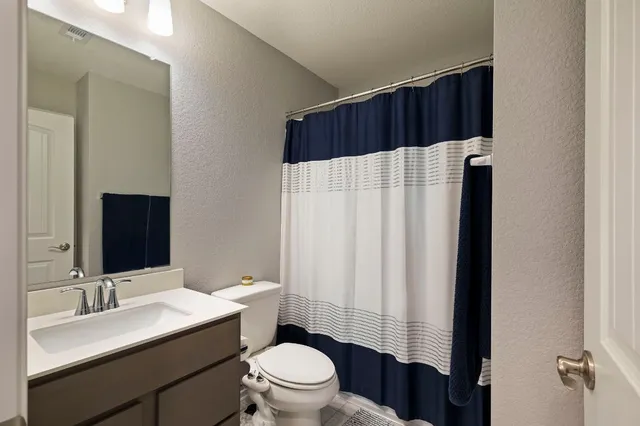 a bathroom with a sink a toilet a shower and a mirror