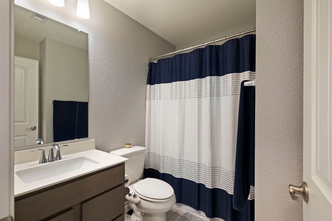 19417 James Carter Jr Street Manor, TX 78653 - Photo 25 of 37 a bathroom with a sink a toilet a shower and a mirror