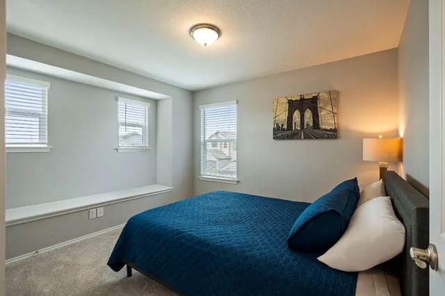 a bedroom with a bed and a painting on the wall