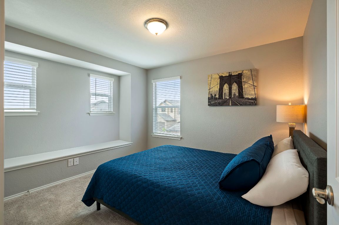 19417 James Carter Jr Street Manor, TX 78653 - Photo 26 of 37 a bedroom with a bed and a painting on the wall