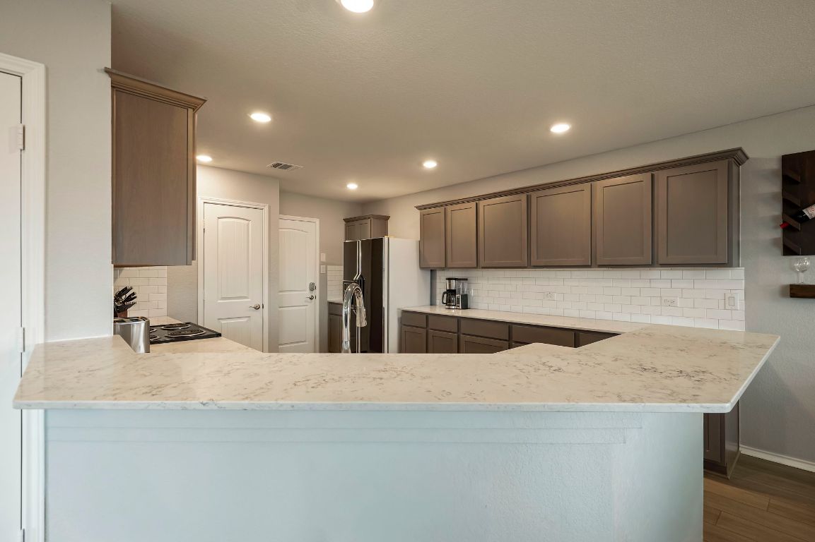 19417 James Carter Jr Street Manor, TX 78653 - Photo 8 of 37 a view of a kitchen with kitchen island a sink and a stove